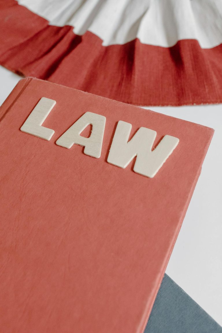 Close-up of a red hardcover law book with bold lettering on a light surface.